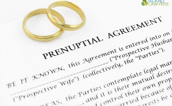 Wedding rings pictured over a prenuptial agreement